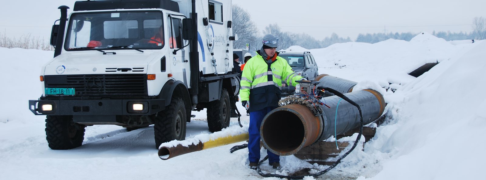 Sideboom crane lowering pipe on a pipeline construction spread