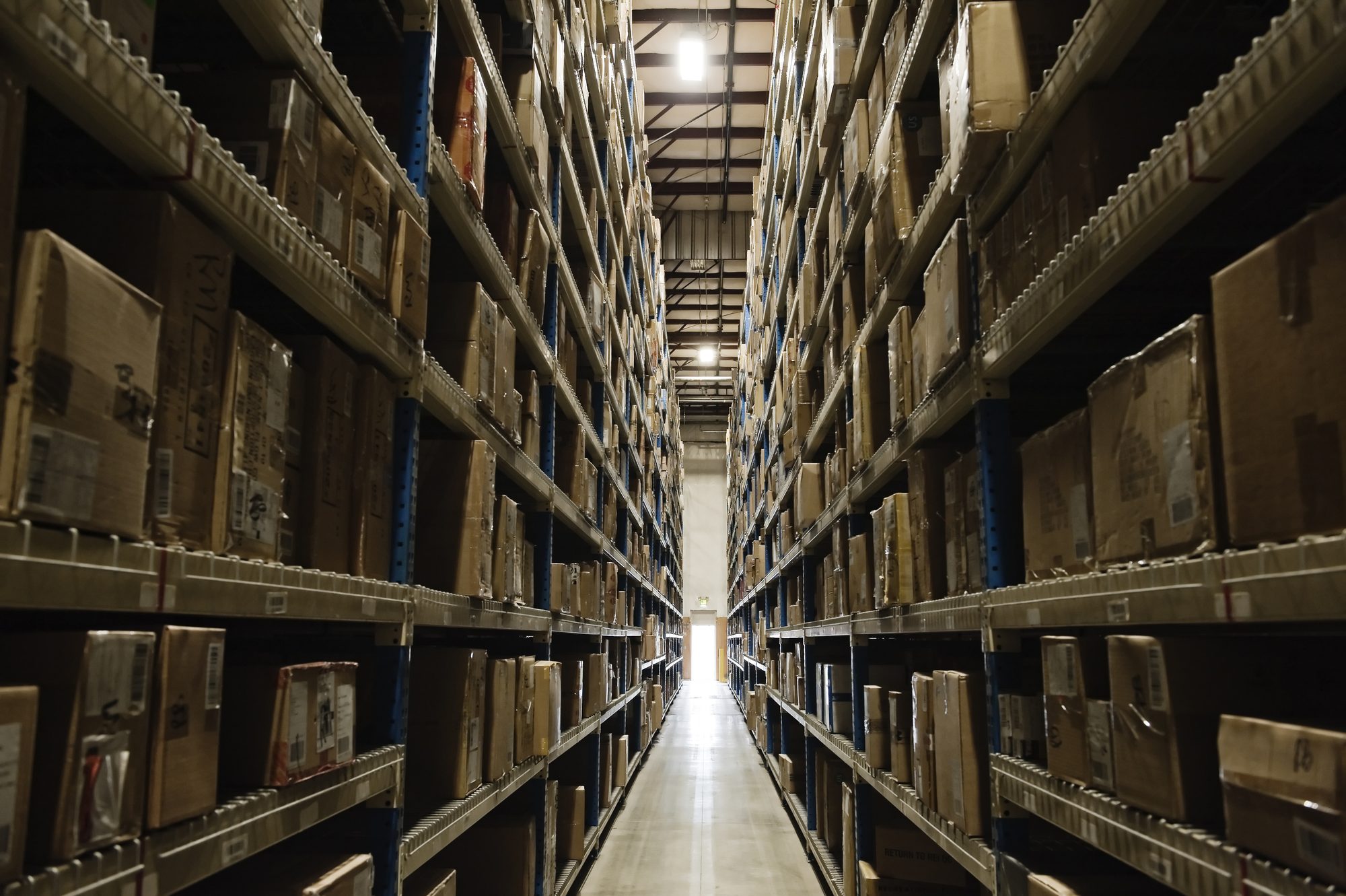 Rows of tall shelving stacked with archived radiographic film records in a climate-controlled storage facility