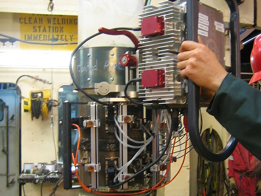 UT Quality crew running an automated ultrasonic (AUT) scanner on a riser aboard an offshore vessel
