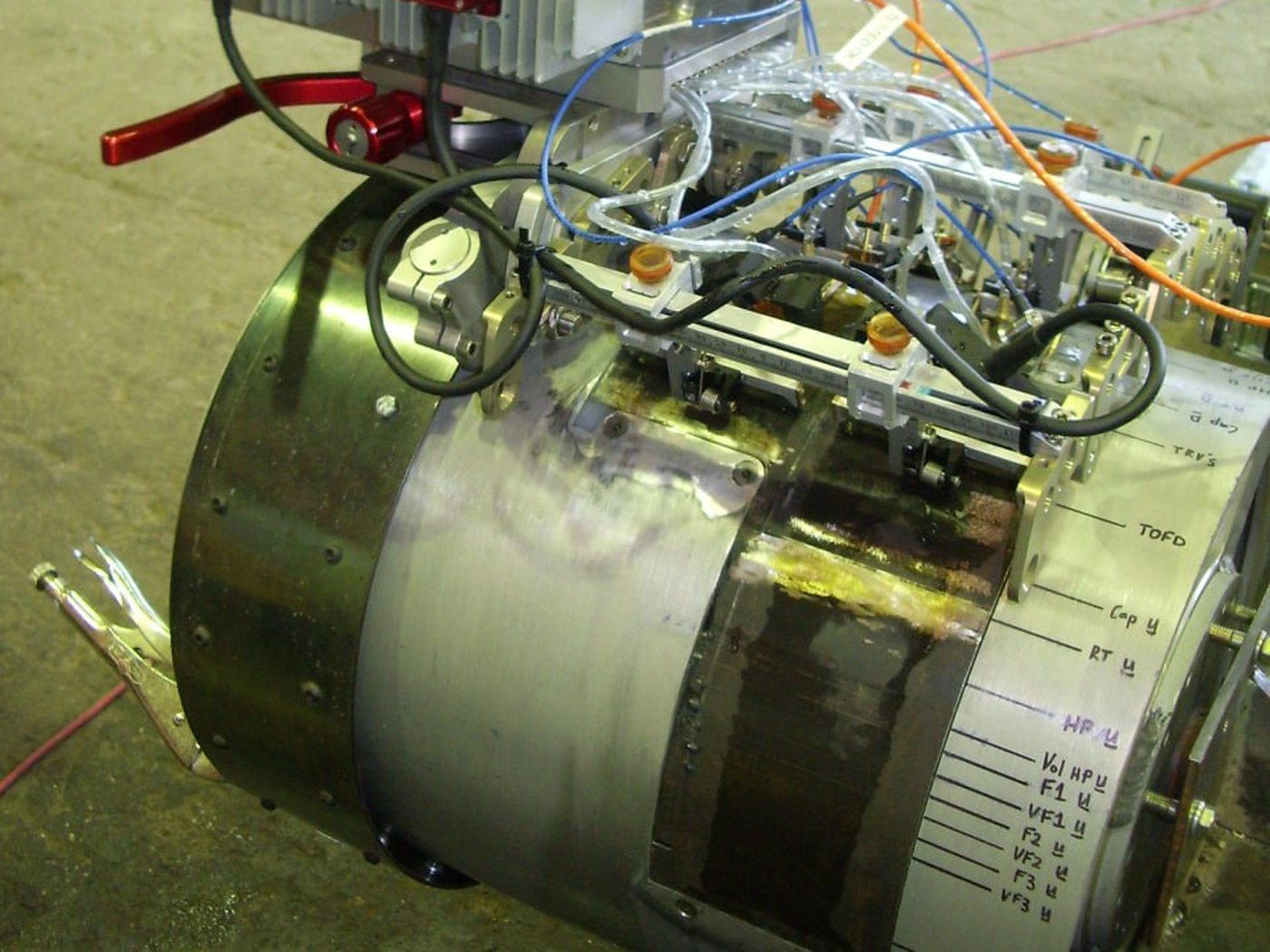 UT Quality automated ultrasonic (AUT) scanner ring with its zonal inspection channels hand-labeled on the band — TOFD, cap, hot pass, fill and volumetric
