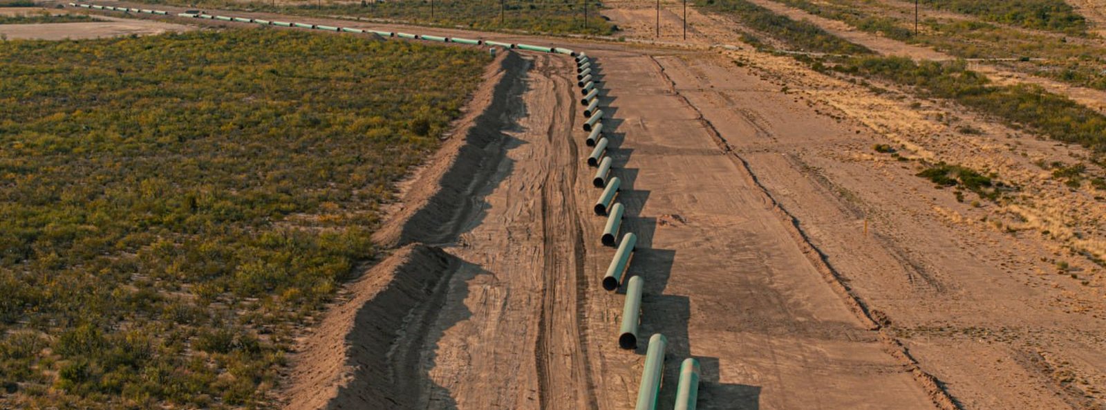 Coated line pipe staged along a right-of-way for weld inspection