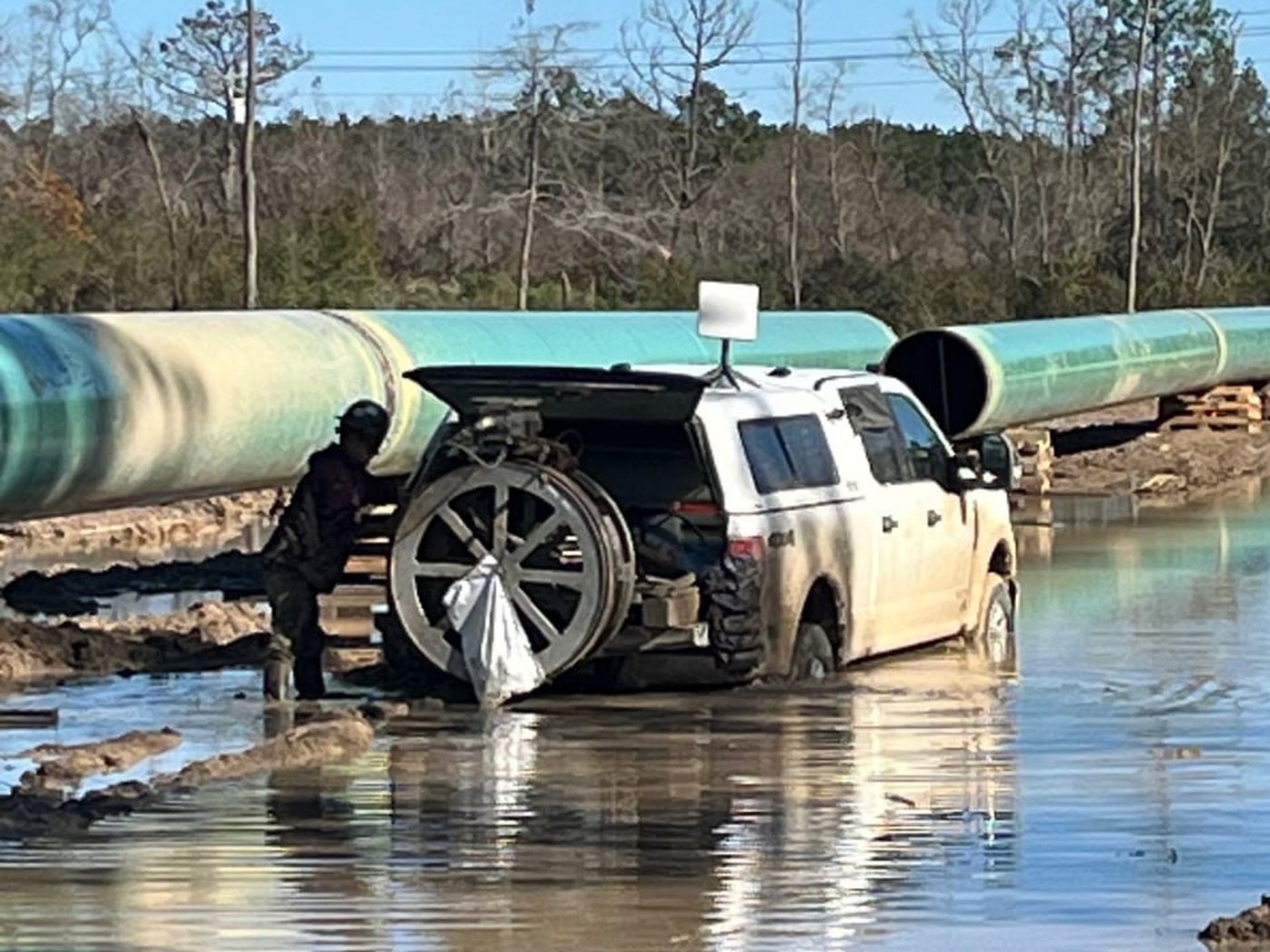 UT Quality technician operating an automated ultrasonic (AUT) scanner on a pipeline weld in the field